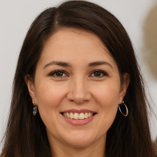 Joyful white young-adult female with long  brown hair and brown eyes