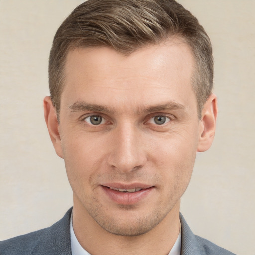 Joyful white young-adult male with short  brown hair and grey eyes