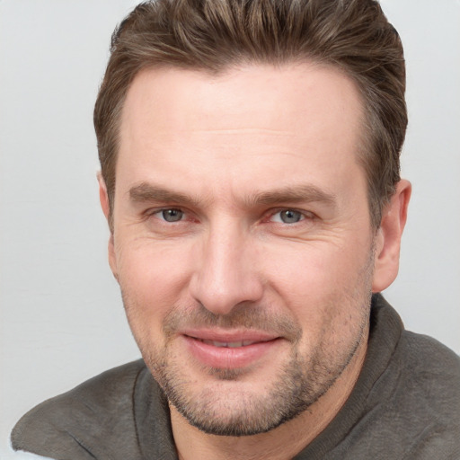 Joyful white adult male with short  brown hair and grey eyes