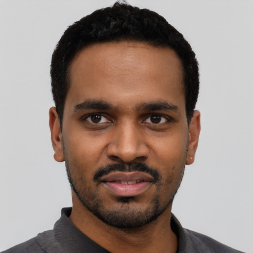 Joyful black young-adult male with short  black hair and brown eyes