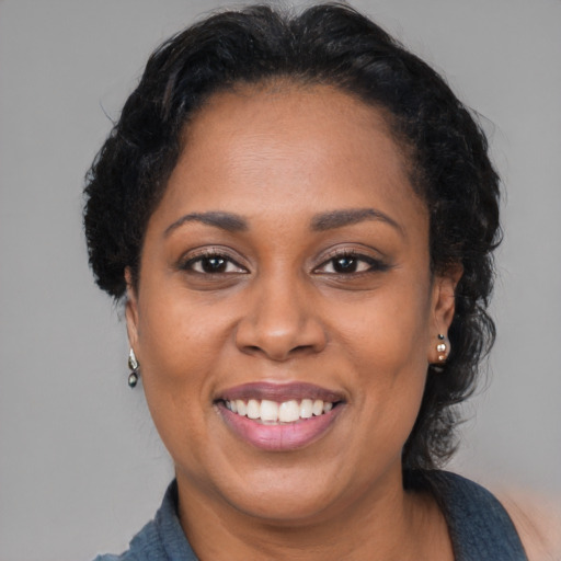 Joyful latino adult female with medium  black hair and brown eyes