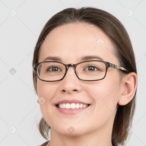 Joyful white young-adult female with medium  brown hair and grey eyes