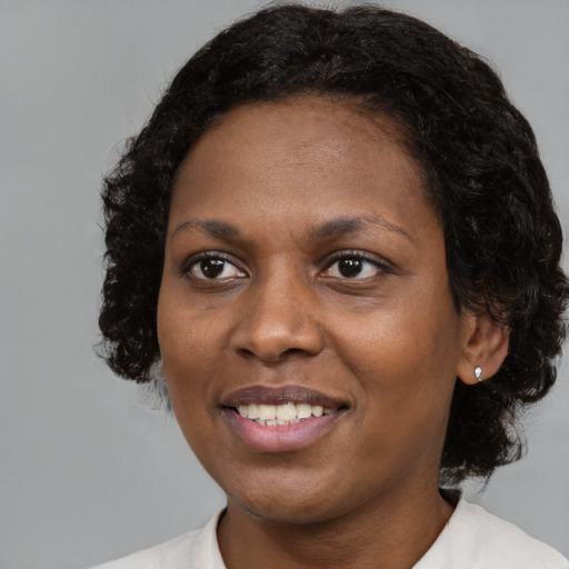 Joyful black young-adult female with medium  black hair and brown eyes