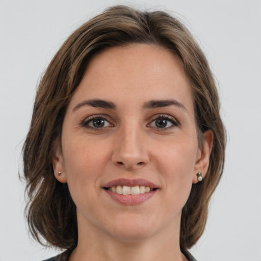 Joyful white young-adult female with medium  brown hair and grey eyes