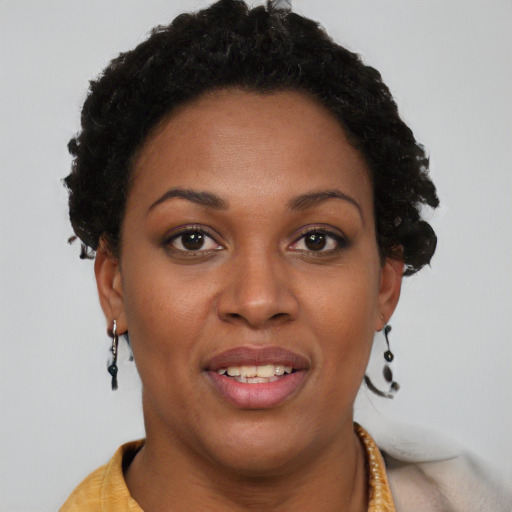 Joyful black young-adult female with short  brown hair and brown eyes