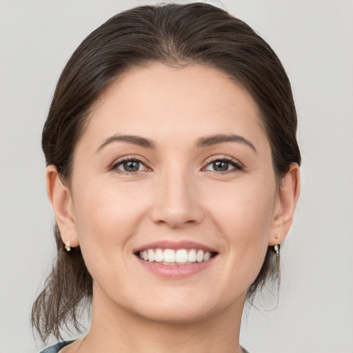 Joyful white young-adult female with medium  brown hair and brown eyes