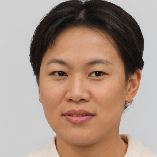 Joyful asian adult female with short  brown hair and brown eyes