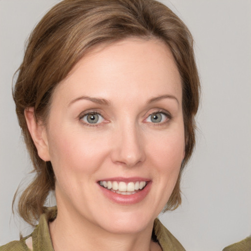 Joyful white young-adult female with medium  brown hair and green eyes