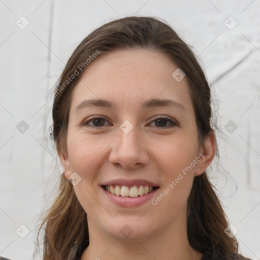 Joyful white young-adult female with long  brown hair and brown eyes