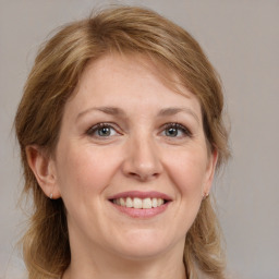 Joyful white adult female with medium  brown hair and grey eyes