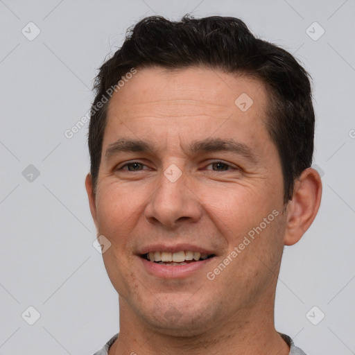 Joyful white adult male with short  brown hair and brown eyes