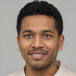 Joyful latino young-adult male with short  black hair and brown eyes