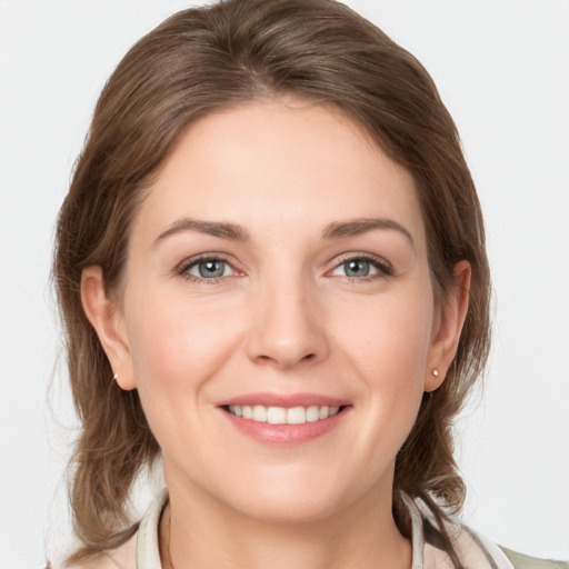 Joyful white young-adult female with medium  brown hair and grey eyes