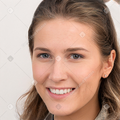 Joyful white young-adult female with long  brown hair and brown eyes