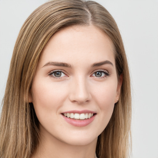 Joyful white young-adult female with long  brown hair and green eyes