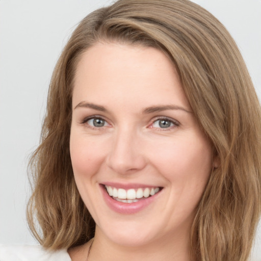 Joyful white young-adult female with long  brown hair and green eyes