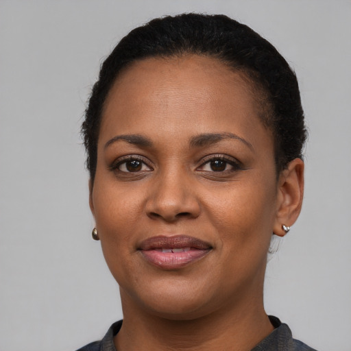 Joyful black young-adult female with short  brown hair and brown eyes