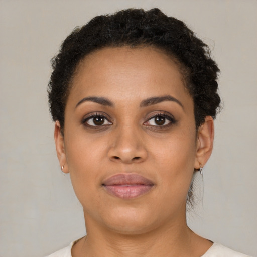 Joyful black young-adult female with short  brown hair and brown eyes