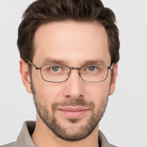 Joyful white adult male with short  brown hair and grey eyes