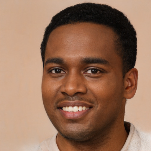 Joyful black young-adult male with short  black hair and brown eyes
