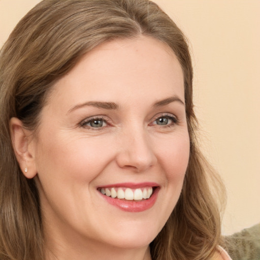 Joyful white young-adult female with long  brown hair and green eyes