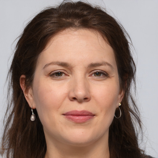 Joyful white adult female with long  brown hair and grey eyes