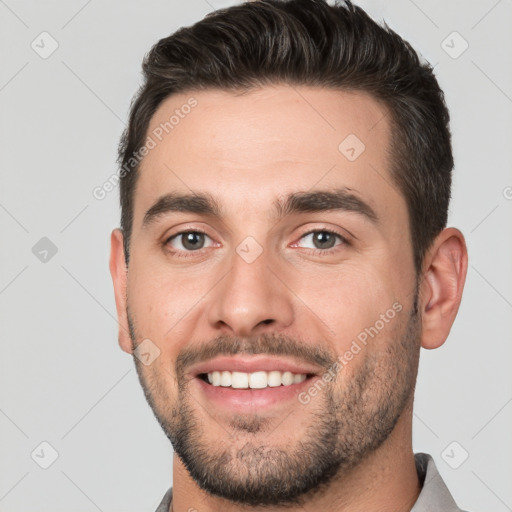 Joyful white young-adult male with short  brown hair and brown eyes