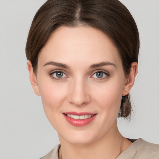 Joyful white young-adult female with short  brown hair and grey eyes