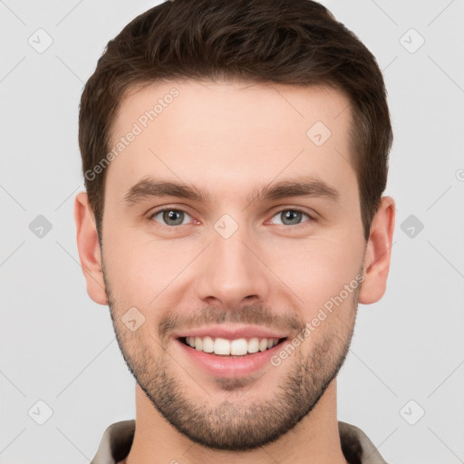 Joyful white young-adult male with short  brown hair and grey eyes