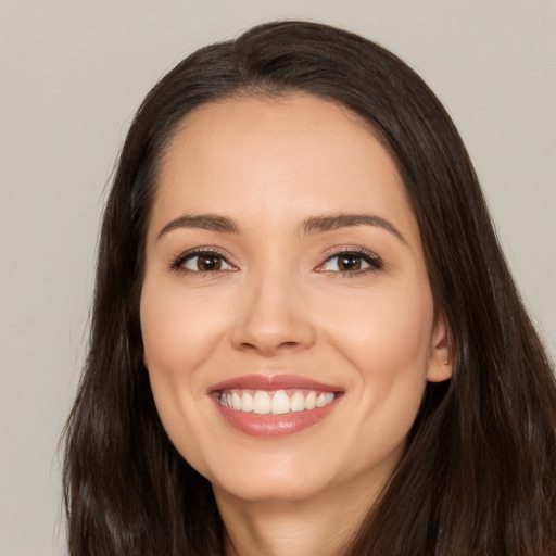 Joyful white young-adult female with long  brown hair and brown eyes