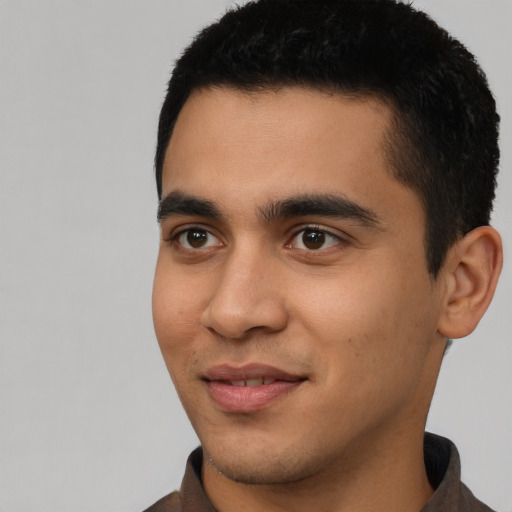 Joyful latino young-adult male with short  black hair and brown eyes