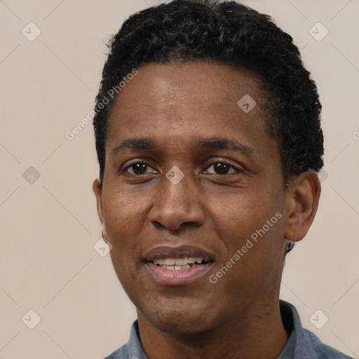 Joyful black adult male with short  black hair and brown eyes