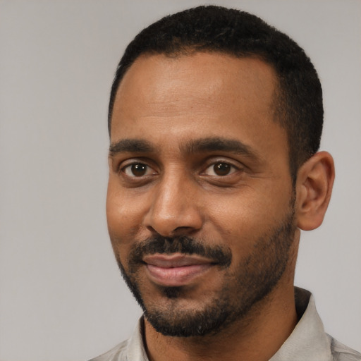 Joyful black young-adult male with short  black hair and brown eyes