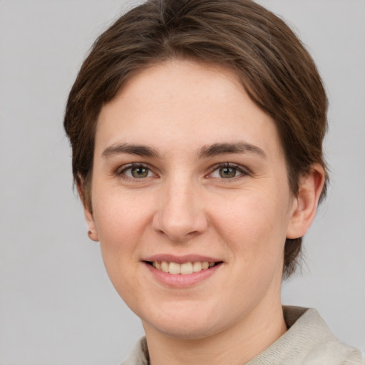 Joyful white young-adult female with short  brown hair and grey eyes