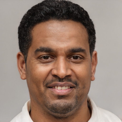 Joyful latino adult male with short  black hair and brown eyes