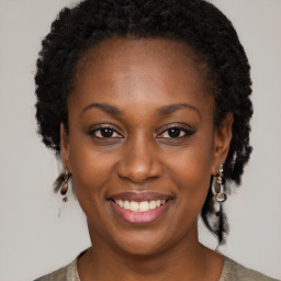 Joyful black young-adult female with long  brown hair and brown eyes