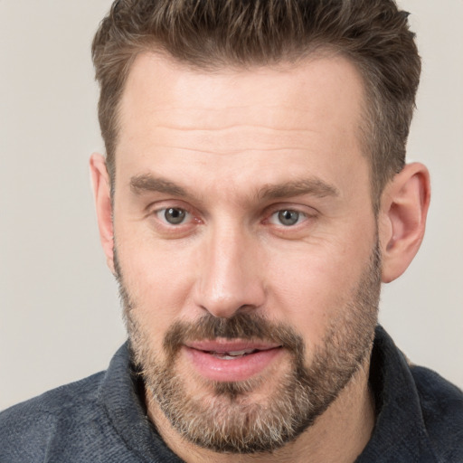 Joyful white adult male with short  brown hair and grey eyes