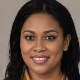 Joyful black young-adult female with long  brown hair and brown eyes