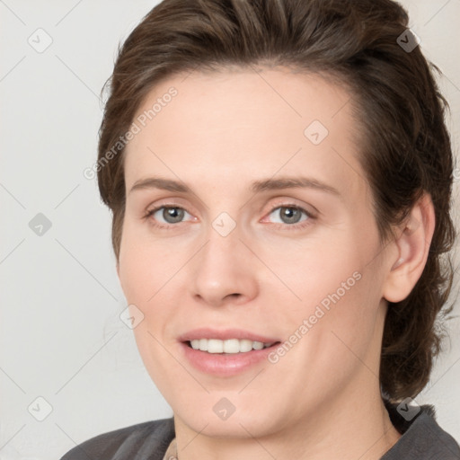 Joyful white young-adult female with medium  brown hair and grey eyes