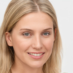 Joyful white young-adult female with long  brown hair and blue eyes