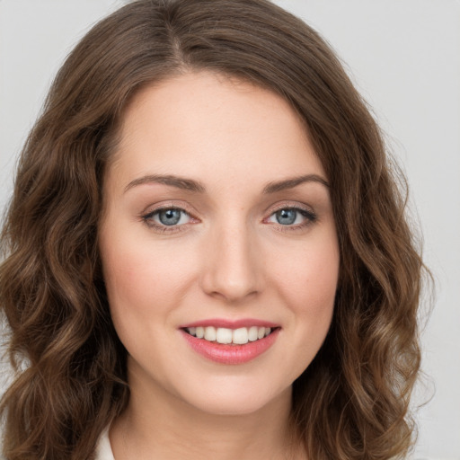 Joyful white young-adult female with long  brown hair and green eyes