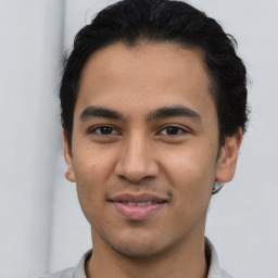 Joyful latino young-adult male with short  brown hair and brown eyes