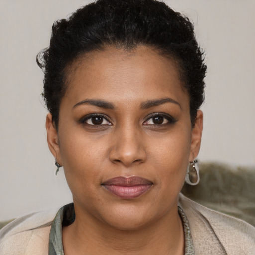 Joyful black young-adult female with short  brown hair and brown eyes