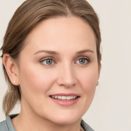 Joyful white young-adult female with medium  brown hair and blue eyes