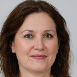 Joyful white adult female with long  brown hair and grey eyes