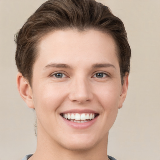 Joyful white young-adult female with short  brown hair and grey eyes