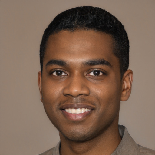 Joyful black young-adult male with short  black hair and brown eyes