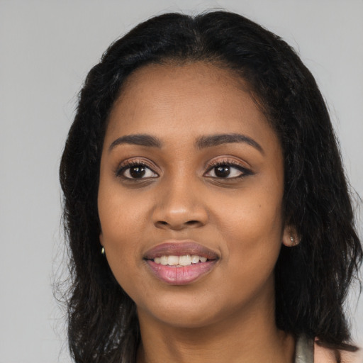 Joyful black young-adult female with long  black hair and brown eyes