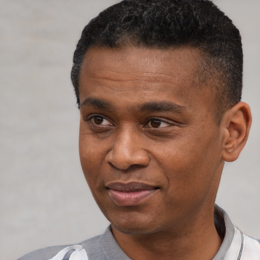 Joyful black young-adult male with short  black hair and brown eyes