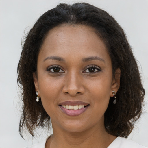 Joyful black young-adult female with medium  brown hair and brown eyes